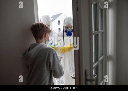 Scientists wearing protective clothing informing people at the door Stock Photo