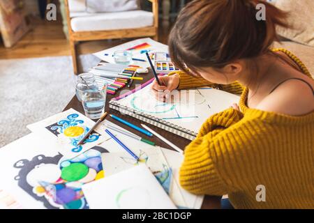Crop view of woman drawing with coloured pencil at home Stock Photo