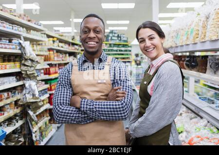Portrait confident grocers working in supermarket Stock Photo
