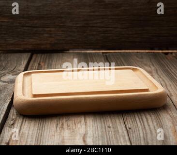 light beige rectangular empty cutting kitchen board on a wooden background from old boards, top view Stock Photo