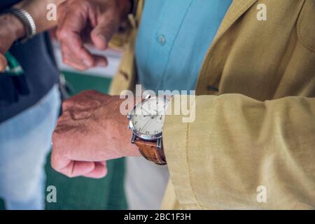 Close up of wrist watch, senior man checking the time Stock Photo