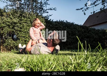 Father playing with little daughter in the garden Stock Photo