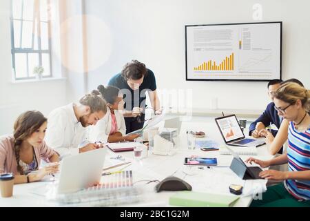 Designers working, talking in conference room meeting Stock Photo