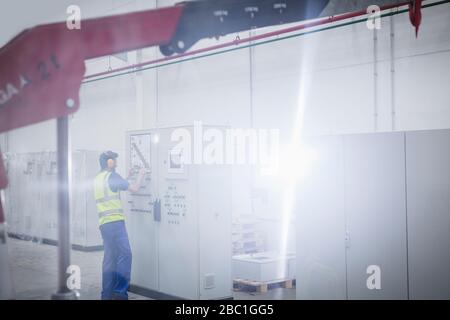 Male worker operating machinery at control panel in factory Stock Photo