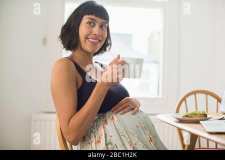 Portrait happy pregnant woman drinking tea Stock Photo