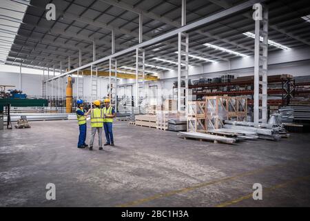 Supervisor and workers talking in warehouse Stock Photo