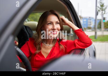 Portrait of smiling mature woman in car Stock Photo