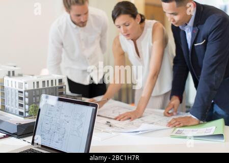 Architects discussing blueprints in meeting Stock Photo