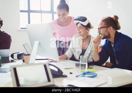 Computer programmers programming virtual reality simulator glasses at computer in office Stock Photo