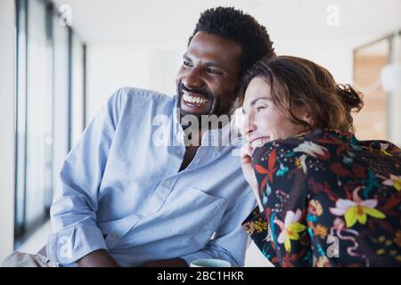 Smiling, enthusiastic multi-ethnic couple looking away Stock Photo