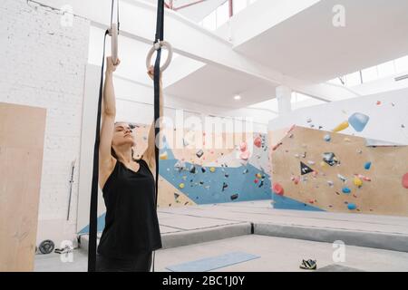 Woman doing stretching exercises before climbing on the wall Stock Photo