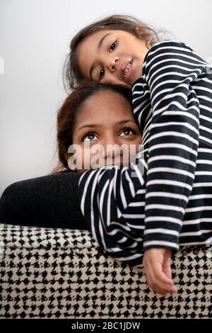 Portrait of happy mother cuddling with her little daughter Stock Photo