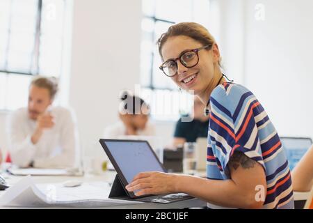 Portrait smiling, confident female architect working at laptop in conference room meeting Stock Photo