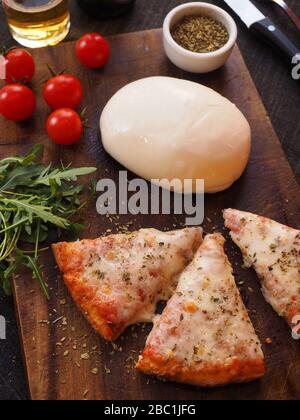 Slices of pizza Margherita with rocket salad, small tomatoes, oregano and Burrata cheese , Italy Stock Photo
