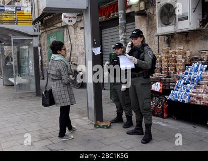 Jerusalem, Israel. 02nd Apr, 2020. Israeli border police check a woman's papers for movement restrictions, because of the coronavirus, Jerusalem, on Thursday, April. 2, 2020. The cases of coronavirus has jumped in Israeli Ultra-Orthodox cities, amid growing concerns of a major outbreak of COVID-19 in the religious communities. Photo by Debbie Hill/UPI Credit: UPI/Alamy Live News Stock Photo