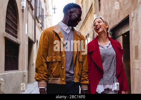 Happy young couple strolling through an alley in the city of Florence, Italy Stock Photo