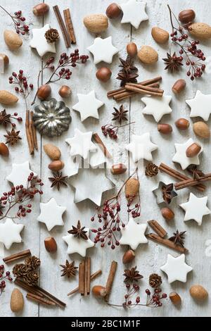 Star shaped cookies, cinnamon sticks, star anise, cookie cutters, pine cones, rose hips, almonds and hazelnuts Stock Photo