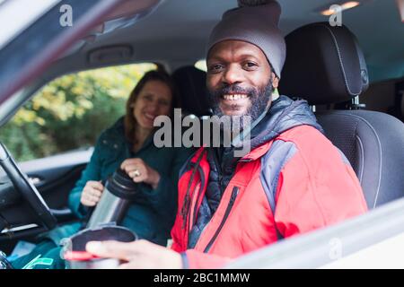 Portrait smiling couple drinking coffee in car Stock Photo