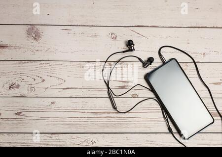 Top view smartphone mockup mobile Blank screen smartphone with earphone on wooden rustic table Stock Photo