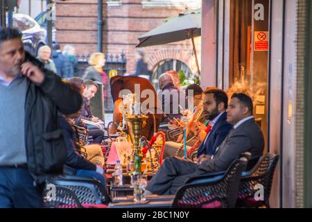 Business people smoking shisha outside lounge bar in Mayfair London Stock Photo