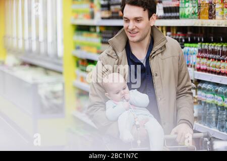 Father and baby daughter shopping in supermarket Stock Photo