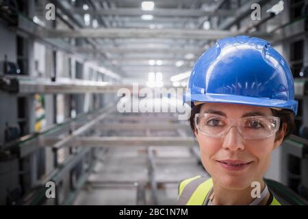 Portrait confident, smiling female worker in steel factory Stock Photo