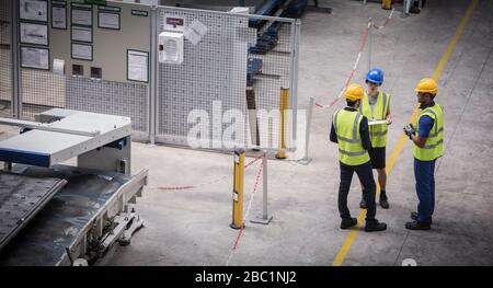 Supervisor and workers talking in factory Stock Photo