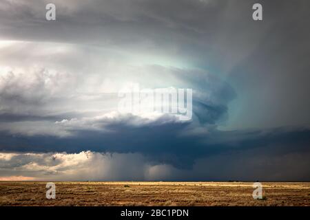 Dark clouds and dramatic sky as a supercell thunderstorm spins in a field during a severe weather event near Artesia, New Mexico Stock Photo