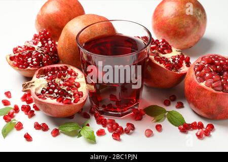 Pomegranate, juice and seeds on white background, close up Stock Photo