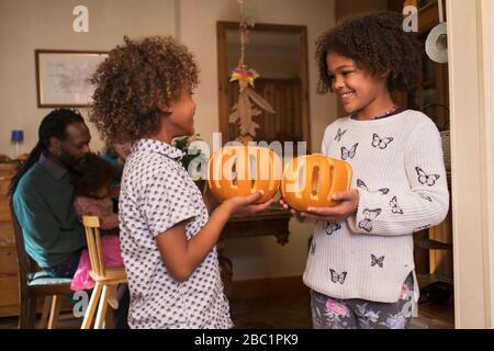 Happy brother and sister holding carved pumpkins Stock Photo