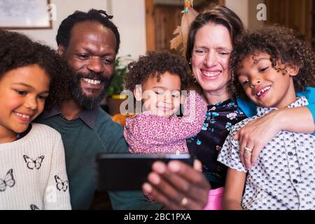 Happy multiethnic family taking selfie with camera phone Stock Photo