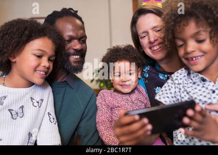 Happy multiethnic family using smart phone Stock Photo