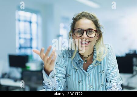 Portrait smiling, confident, gesturing businesswoman in office Stock Photo