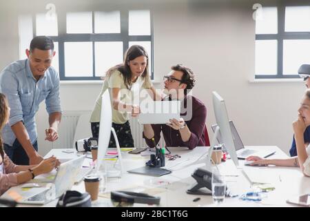 Designers working at computers and laptops in open plan office Stock Photo
