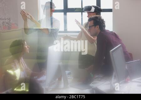 Computer programmers testing virtual reality simulator glasses in office Stock Photo