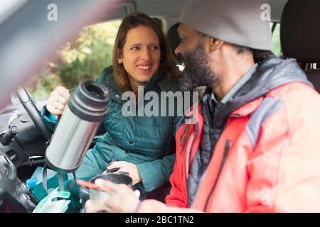 Happy couple drinking coffee in car Stock Photo