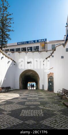 A couple walking through a pedestrian tunnel to the beach in Albufeira in the Algarve, Portugal Stock Photo