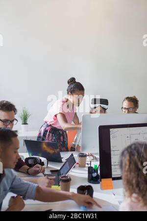 Computer programmers and designers working at computers in open plan office Stock Photo
