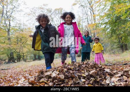 Playful family running in autumn leaves Stock Photo