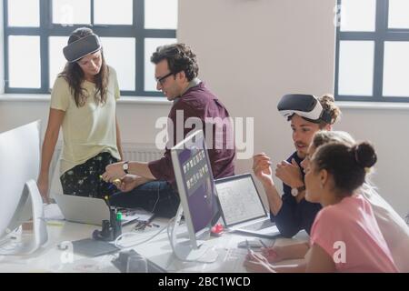 Computer programmers programming virtual reality simulator glasses in office Stock Photo