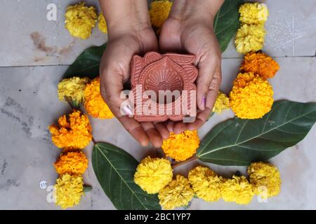 Swastika made using Marigold flowers for Ugadi with Clay Oil Lamp Stock Photo