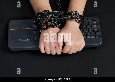 Female hands Chained to Keyboard, addiction concept Stock Photo