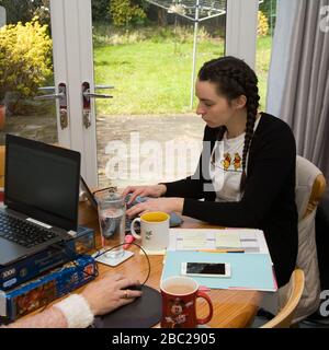 Female office worker sitting at table working from home Stock Photo