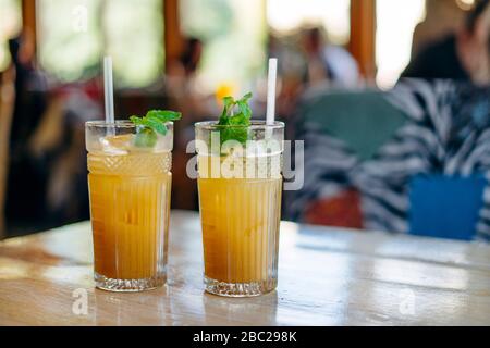 two glasses of fresh lemonade with ice on table in summer cafe Stock Photo