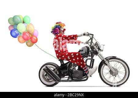 Full length profile shot of a clown riding a chopper motorbike with a bunch of balloons isolated on white background Stock Photo