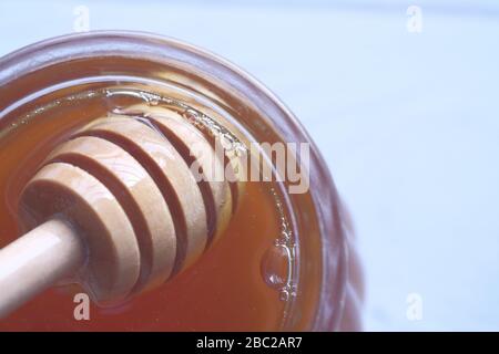 Honey pot and dipper isolated on white background. Stock Photo
