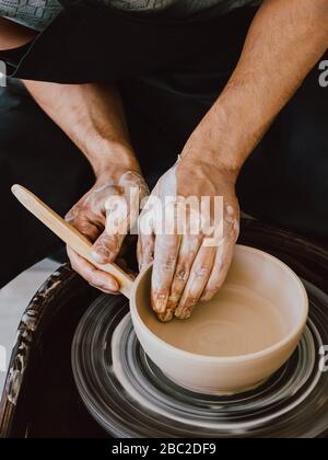 Potter at work Top view photo Ceramist is bringing finishing touches to a new ceramic cup Stock Photo