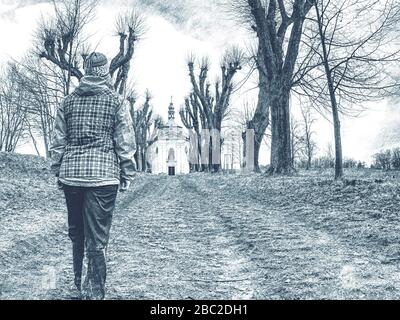 Woman walking on a country road through autumn tree avenue without leaves. Dashed pencil sketch effect. Stock Photo