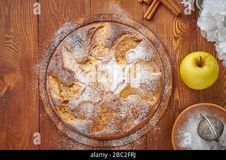 Apple french cake with apples, cinnamon on dark wooden kitchen table, top view Stock Photo