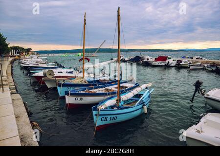 Colorful fishing boats anchored in port in Selce, Croatia before the incoming storm Stock Photo